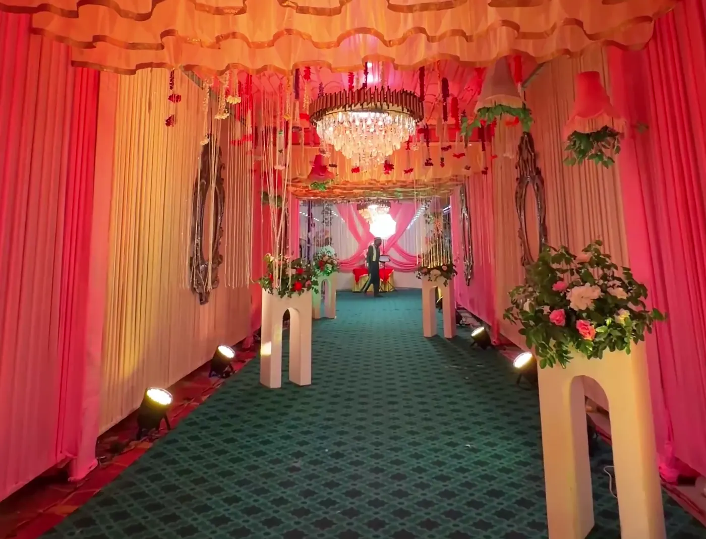 Walkway draped in fabric with a chandelier overhead