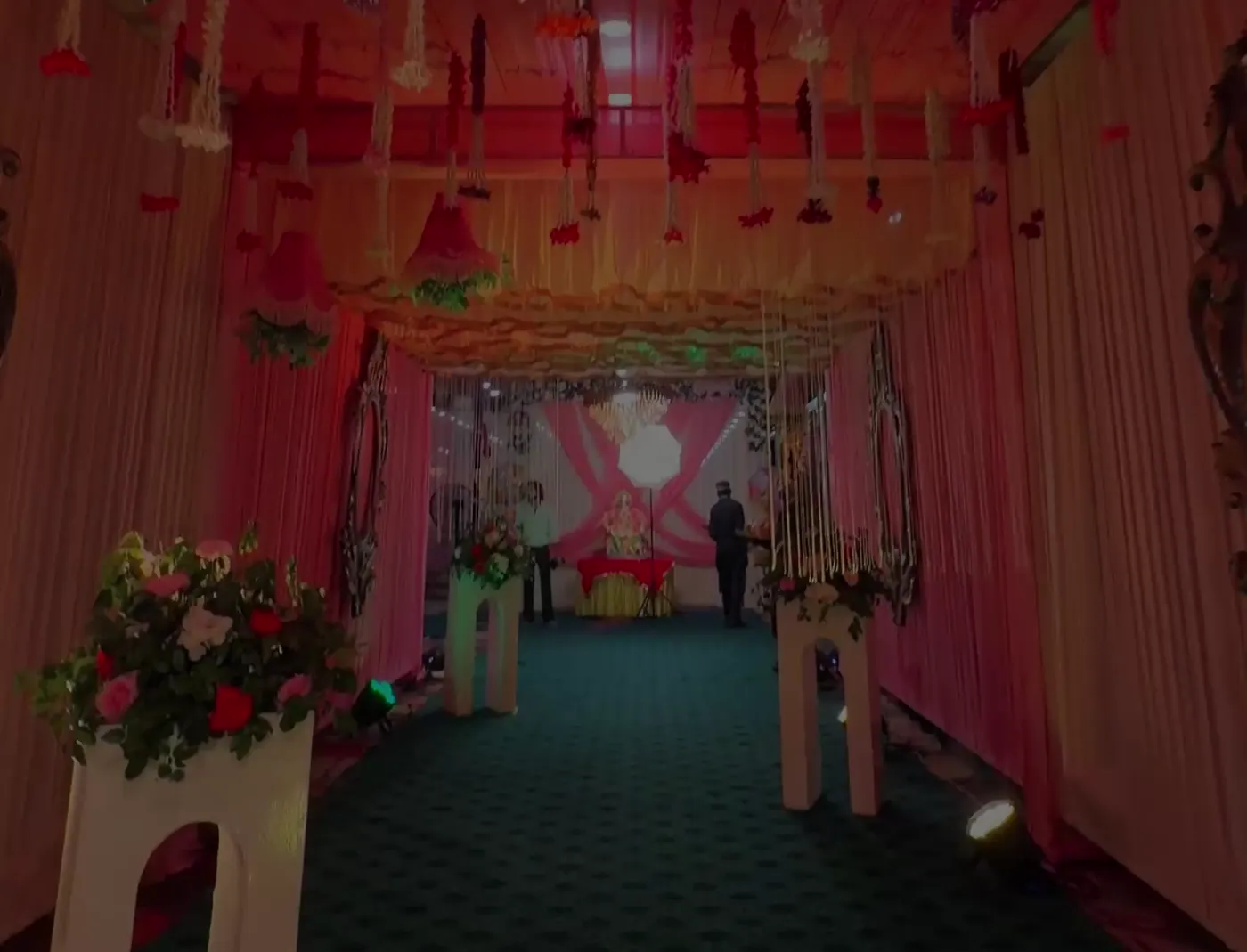 Floral walkway with pink drapes at night