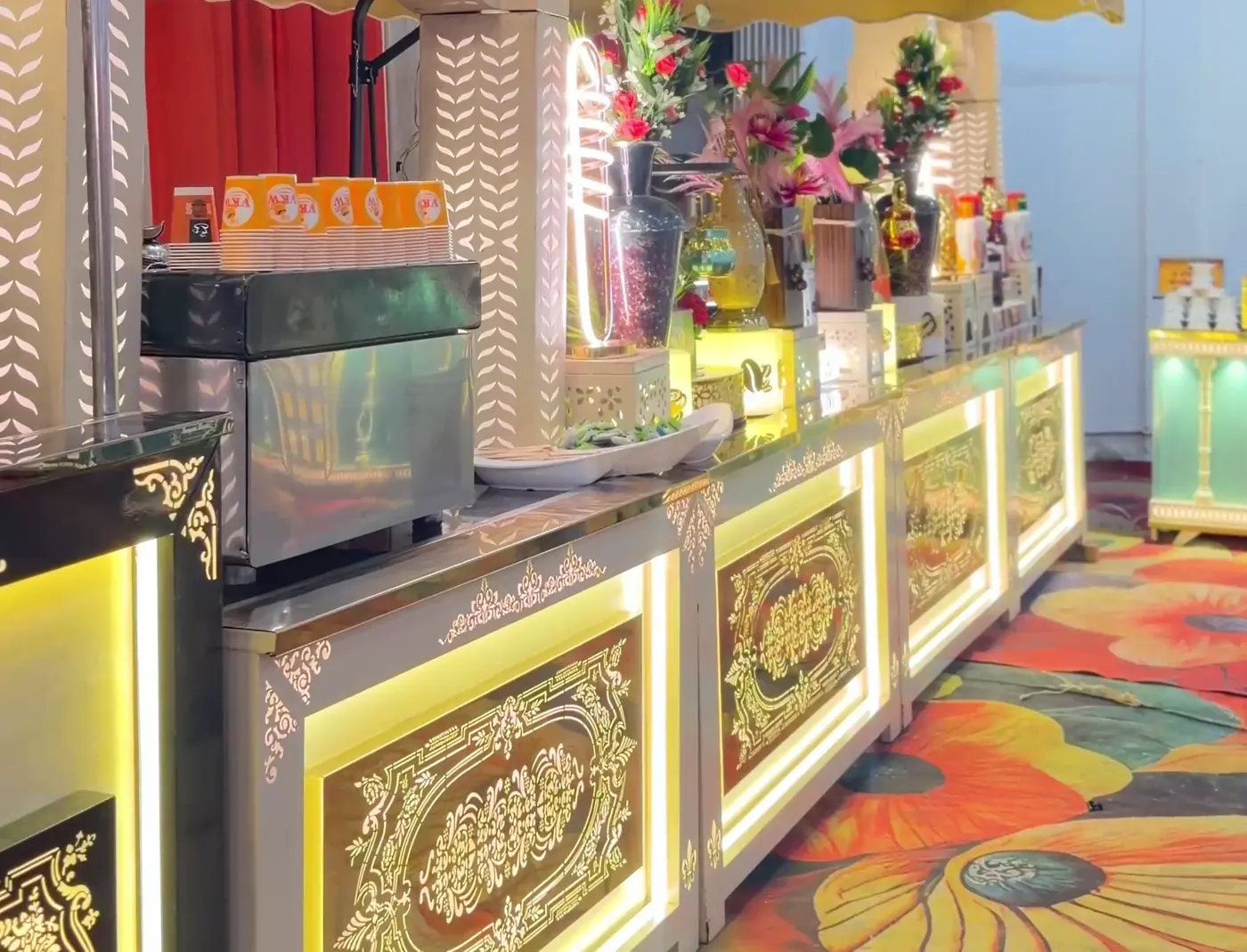 Illuminated buffet counter with patterned panels on a floral carpet